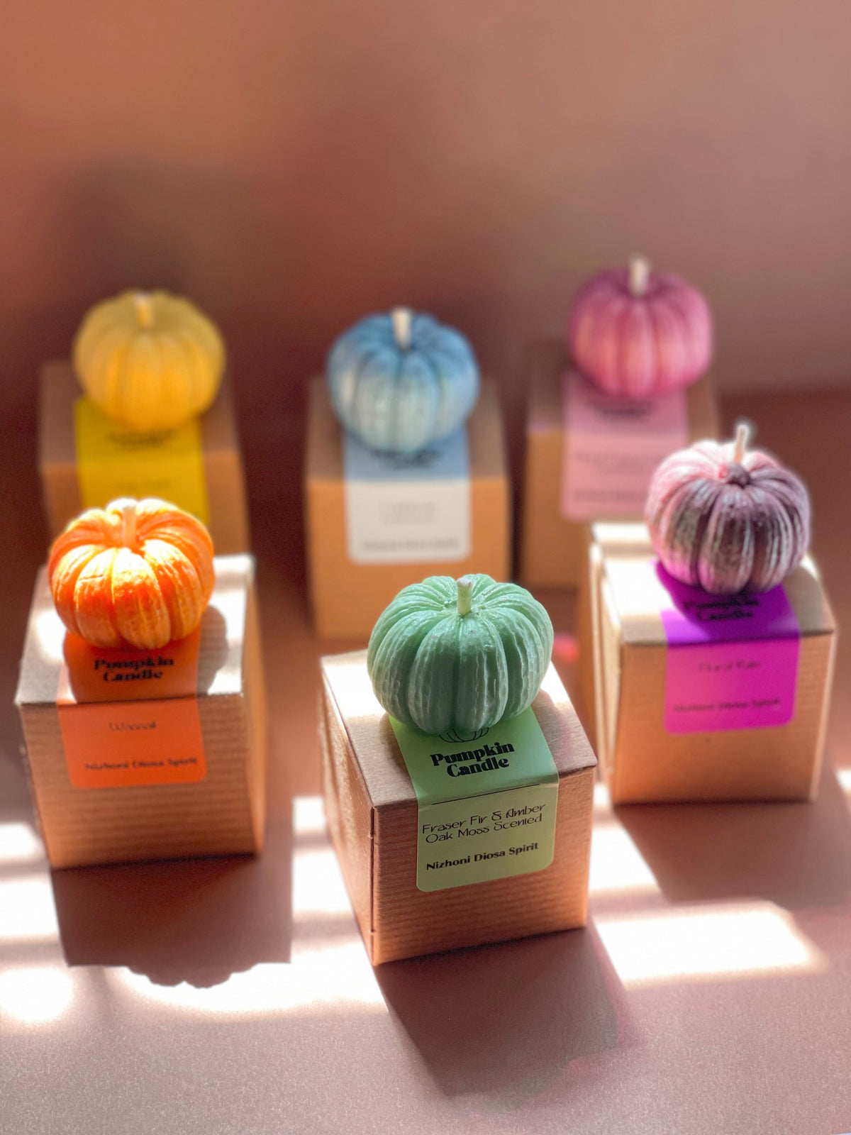 Close-up of handmade pumpkin-shaped scented candle with detailed autumn design